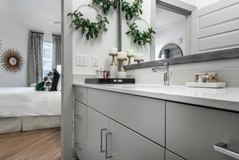 a kitchen with gray cabinets and white countertops